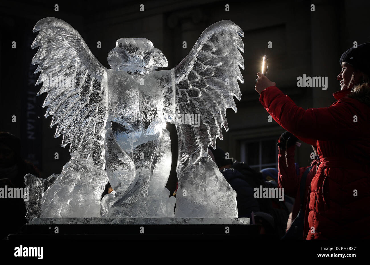 Une femme d'une des photographies de sculptures en glace un griffon, une partie du sentier de glace de New York, dans le Yorkshire, après une nuit de neige hier et devraient entraîner des troubles. Banque D'Images