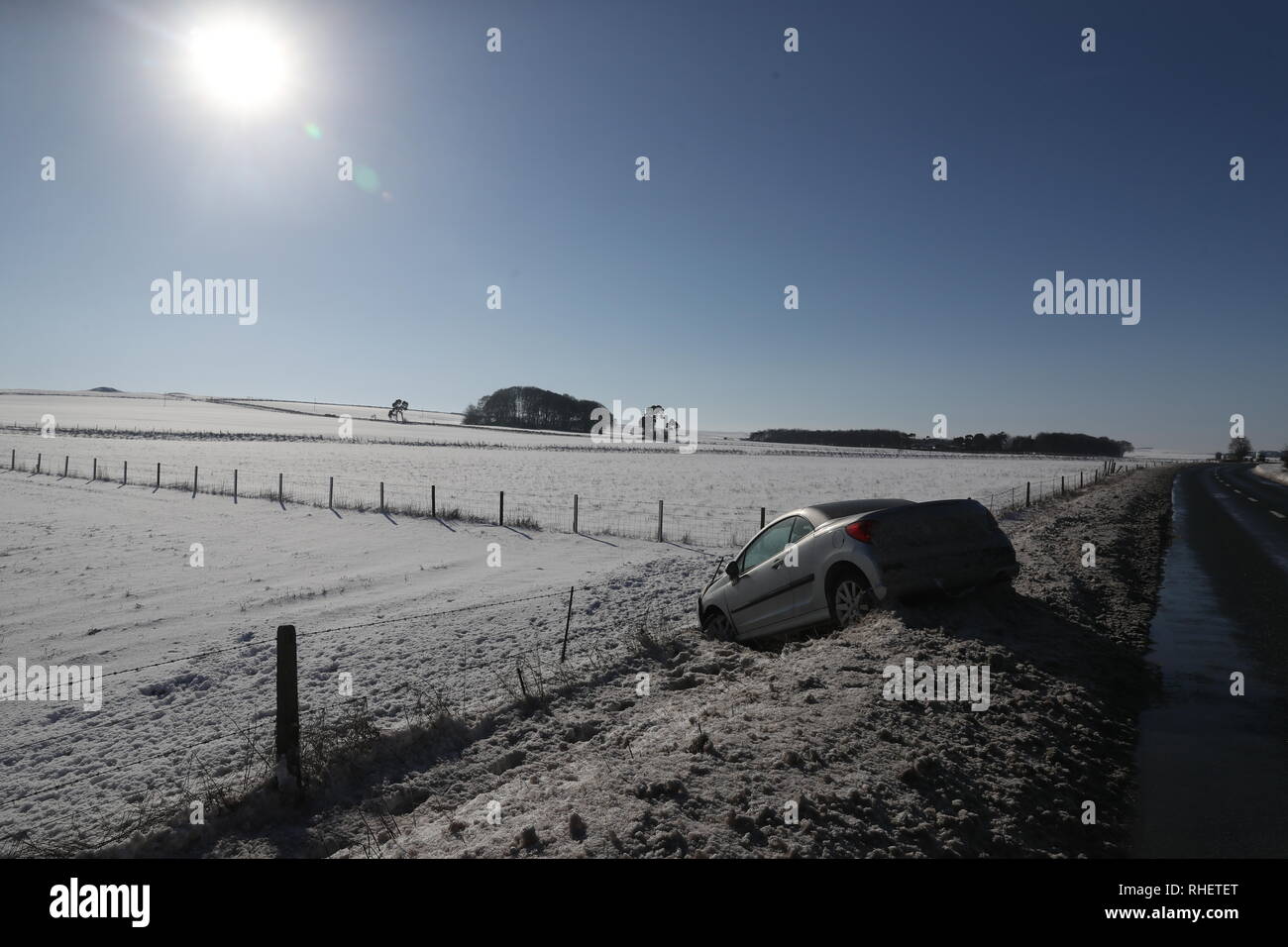 Un véhicule dans un fossé près d'Avebury dans le Wiltshire. Neige et continué dans les premières heures du samedi matin sur les routes à travers le Kent et le Hampshire, et causant des conditions dangereuses. Banque D'Images