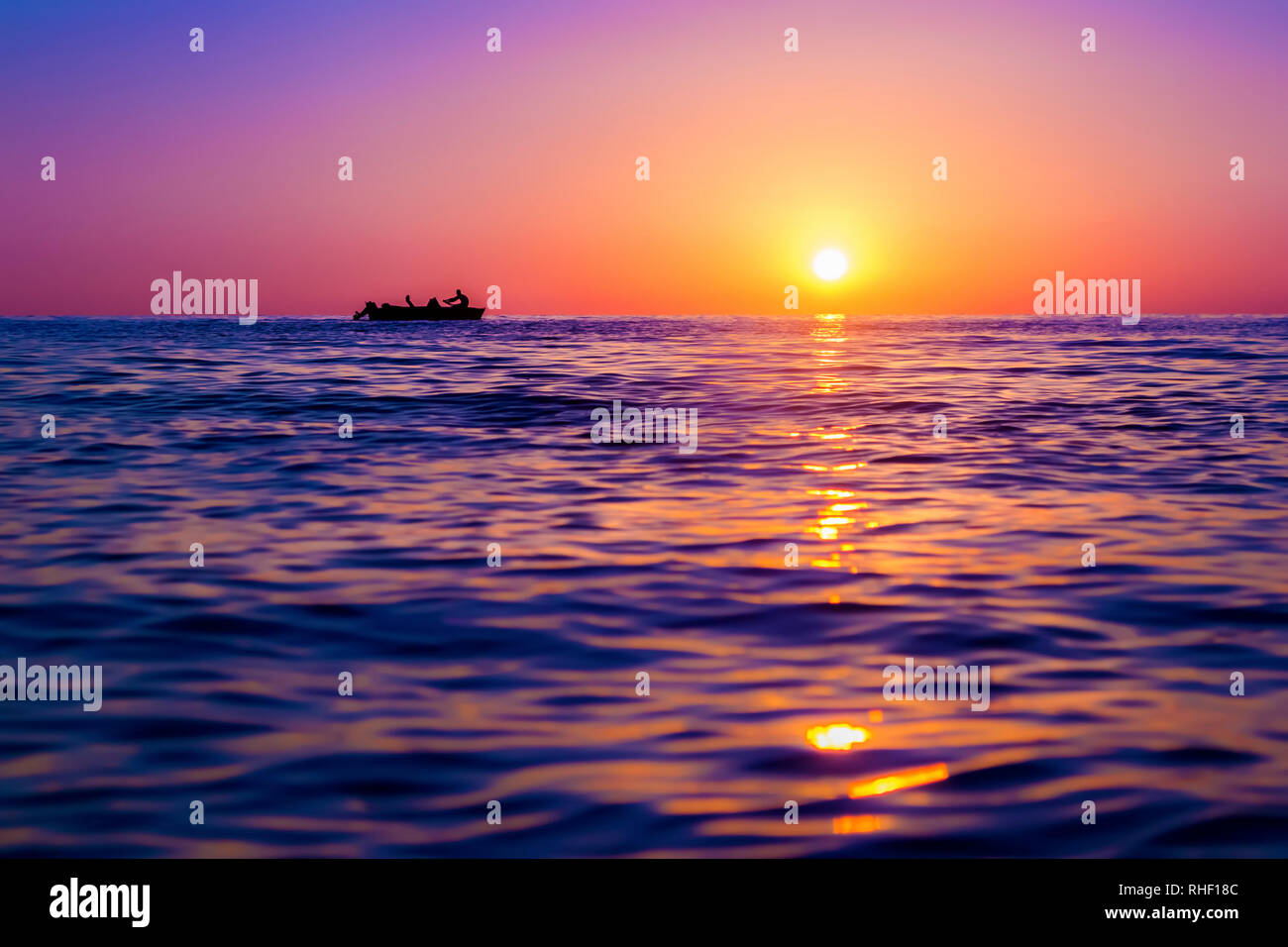 Soir paysage marin. Silhouette of man sur la ligne bateau contre le soleil  couchant. Le soleil réfléchis par les vagues. Violet, rose et jaune. La  Géorgie Photo Stock - Alamy