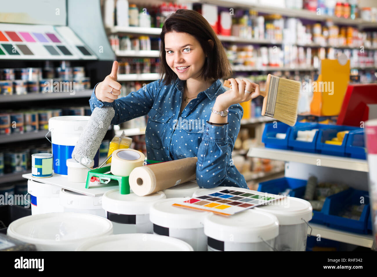 18-25 ans fille est l'achat d'outils pour l'amélioration de maison magasin de fournitures de peinture. Banque D'Images