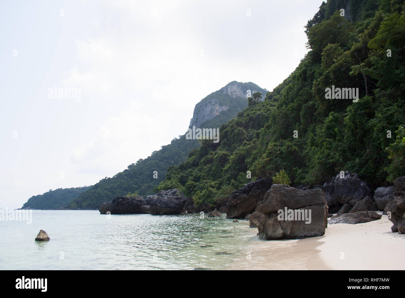 Cap falaise avec une épaisse forêt et de grosses pierres dans un port de Ko Wua Ta Lap island, Thaïlande Banque D'Images