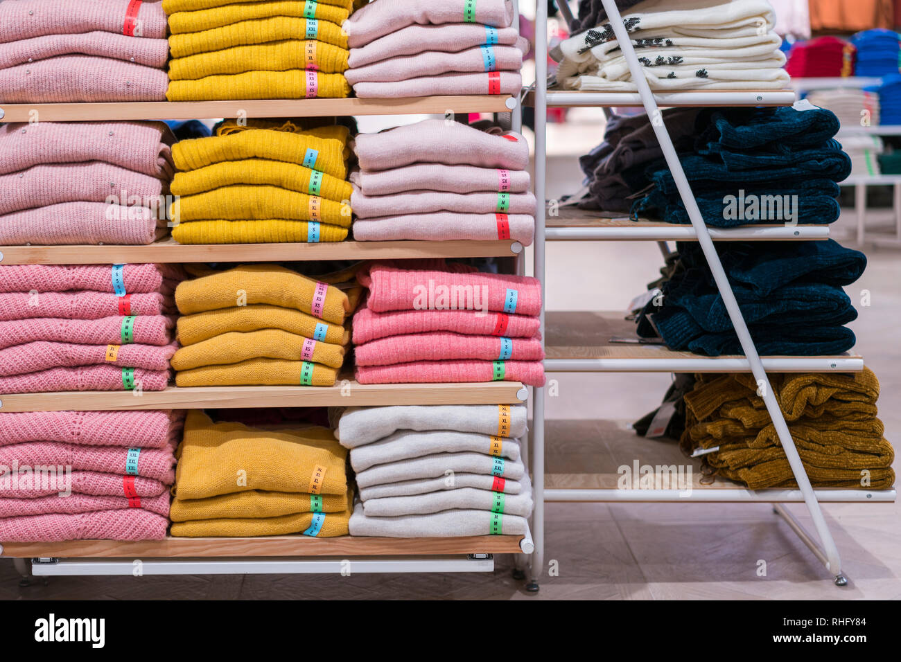 Neat des piles de vêtements pliés sur les étagères des magasins. Pliage  couleur shirt dans un magasin de vêtements bien organisés Photo Stock -  Alamy