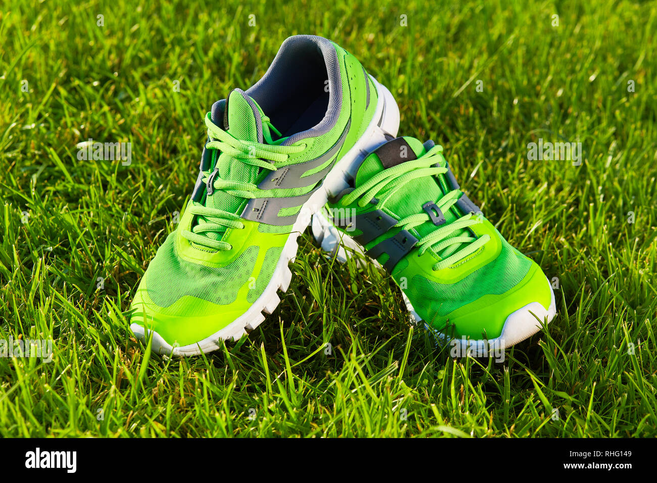Près de nouvelles paires de chaussures de course verte / chaussures sneaker sur champ d'herbe verte dans le parc. Avec un espace réservé au texte ou dessin Banque D'Images