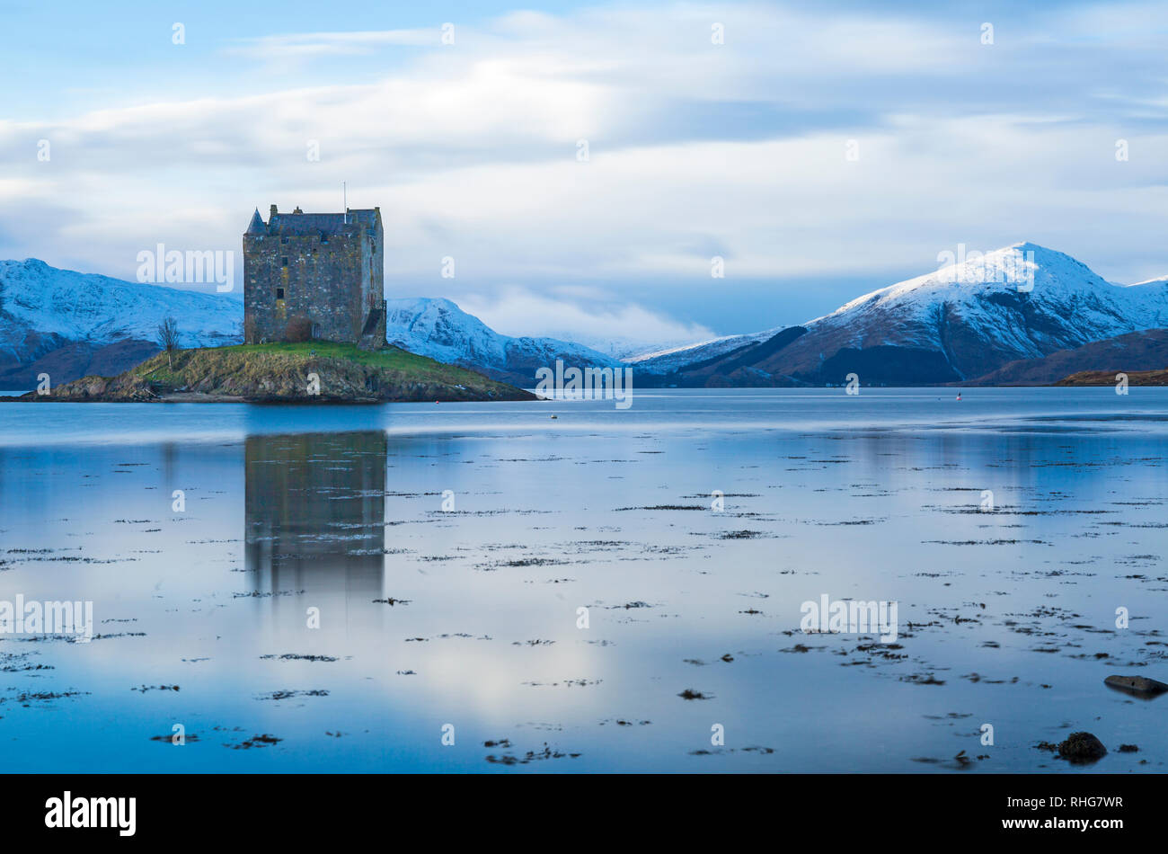 Château de Stalker avec réflexion sur le Loch Laich d'entrée d'un off le Loch Linnhe au crépuscule, Highlands, en Écosse avec ses montagnes couvertes de neige, hiver - long exposure Banque D'Images