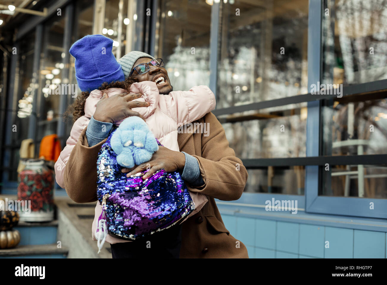 Transmission d'heureux père serrant ses cute little girl wearing backpack Banque D'Images