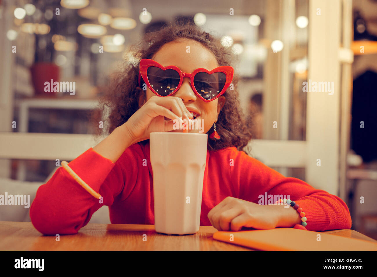 Appel Curly girl wearing bracelets en compagnie de ses milkshake Banque D'Images