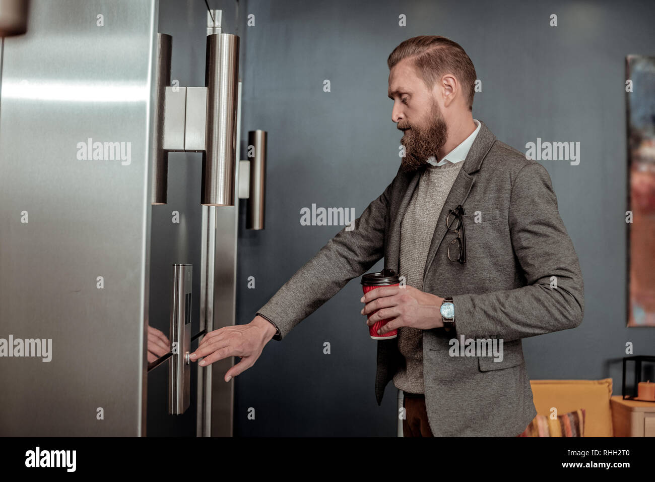 Concentrated businessman poussant le bouton de l'ascenseur Banque D'Images