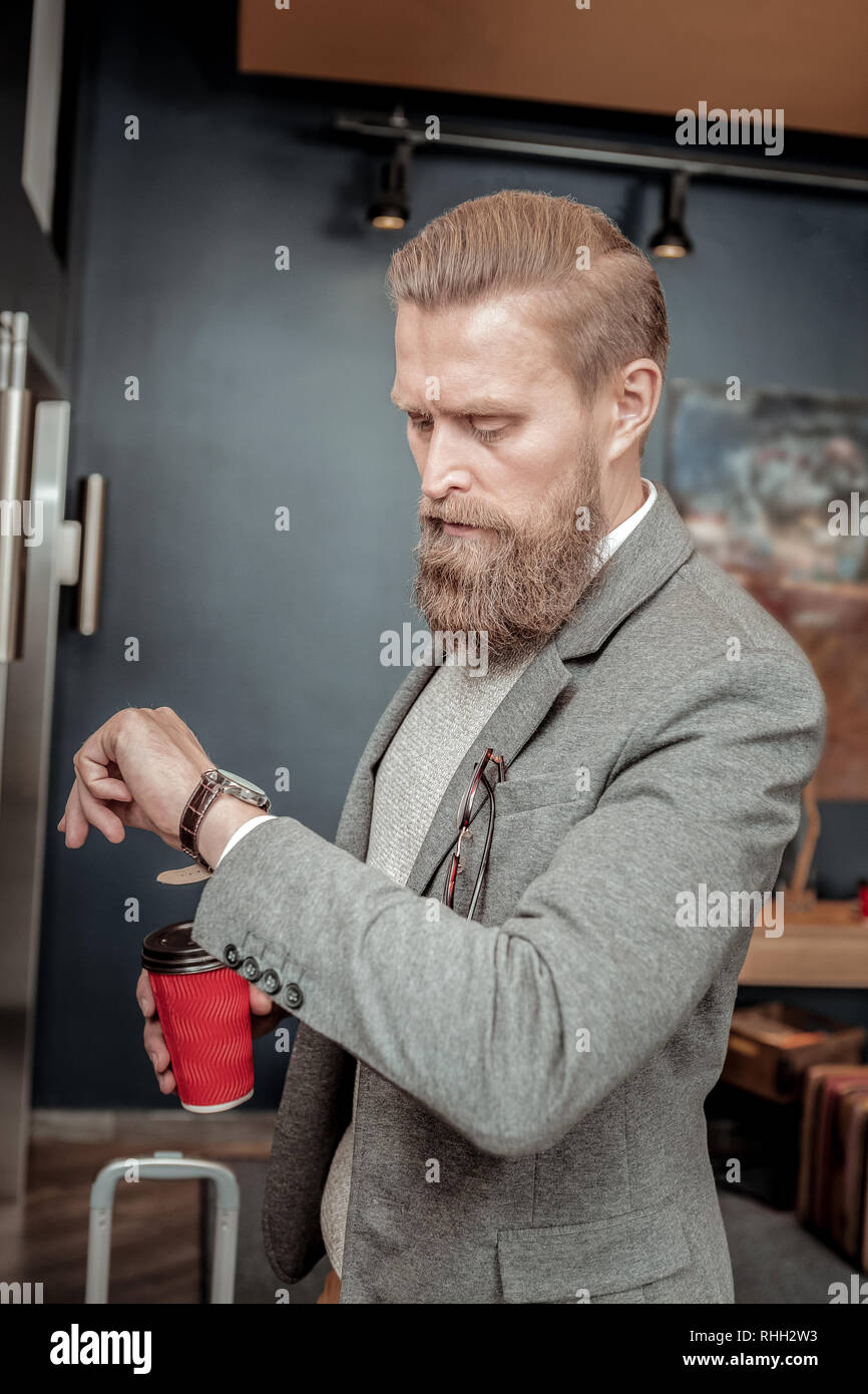 Homme barbu attentif à ses montres à Banque D'Images