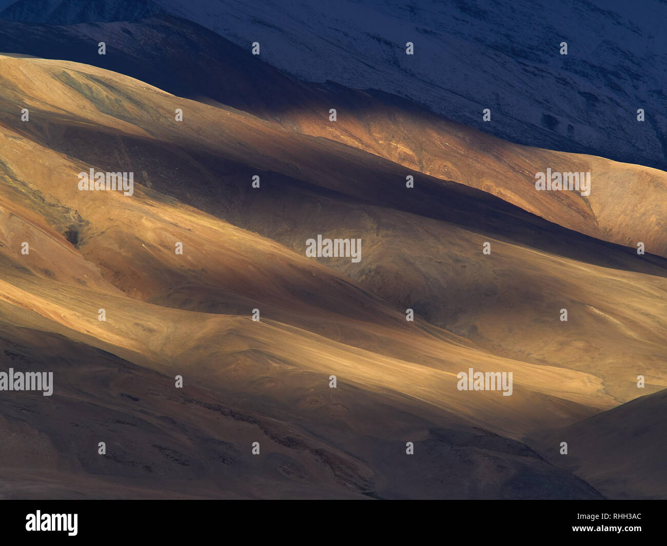 Photo naturelle de la lumière et les ombres : rayures d'ombre sur la pente de la montagne jaune. Banque D'Images