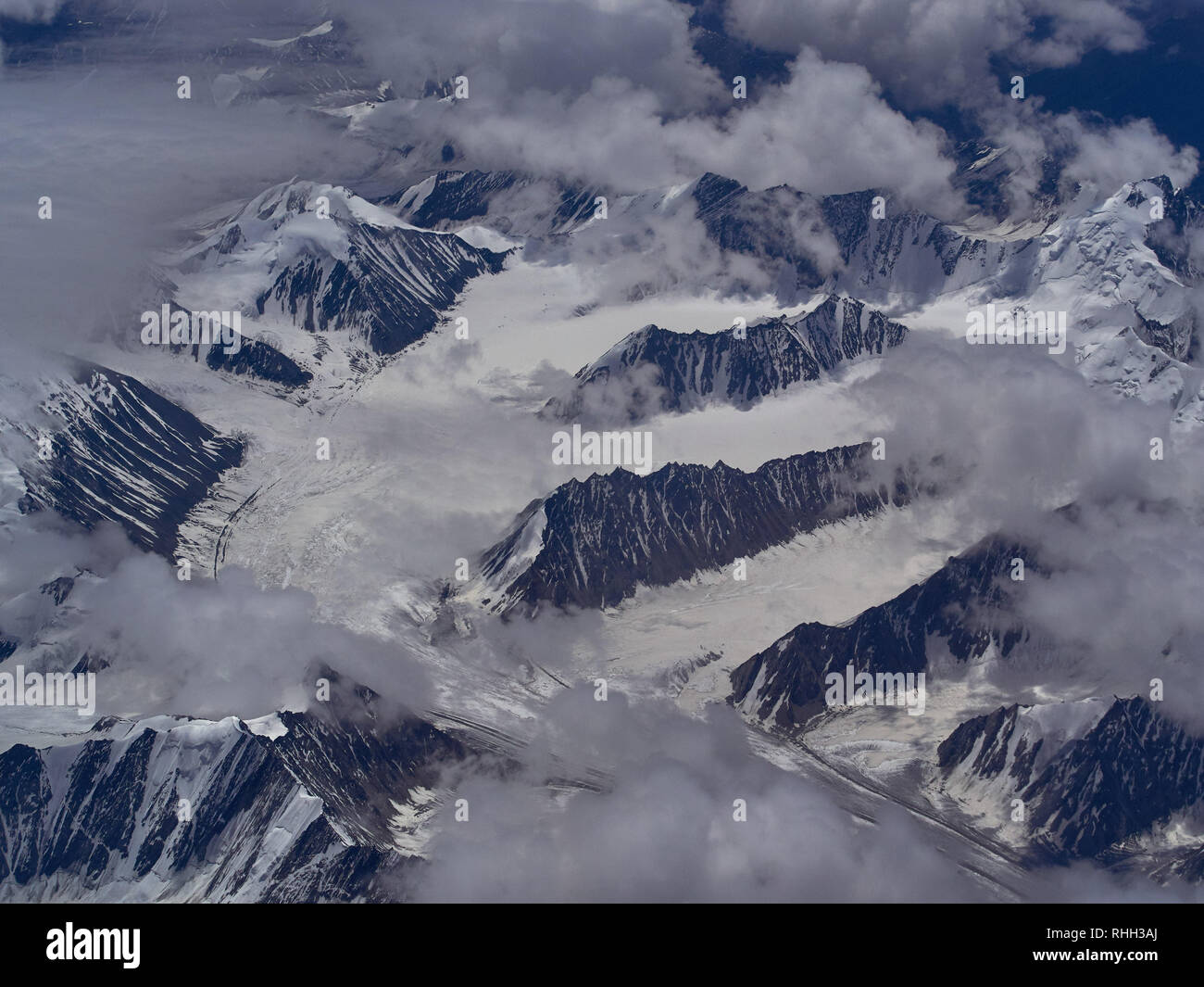 Les sommets du glacier au milieu des nuages : les bords de la partie supérieure de la roche entre la glace et la neige blanche. Banque D'Images