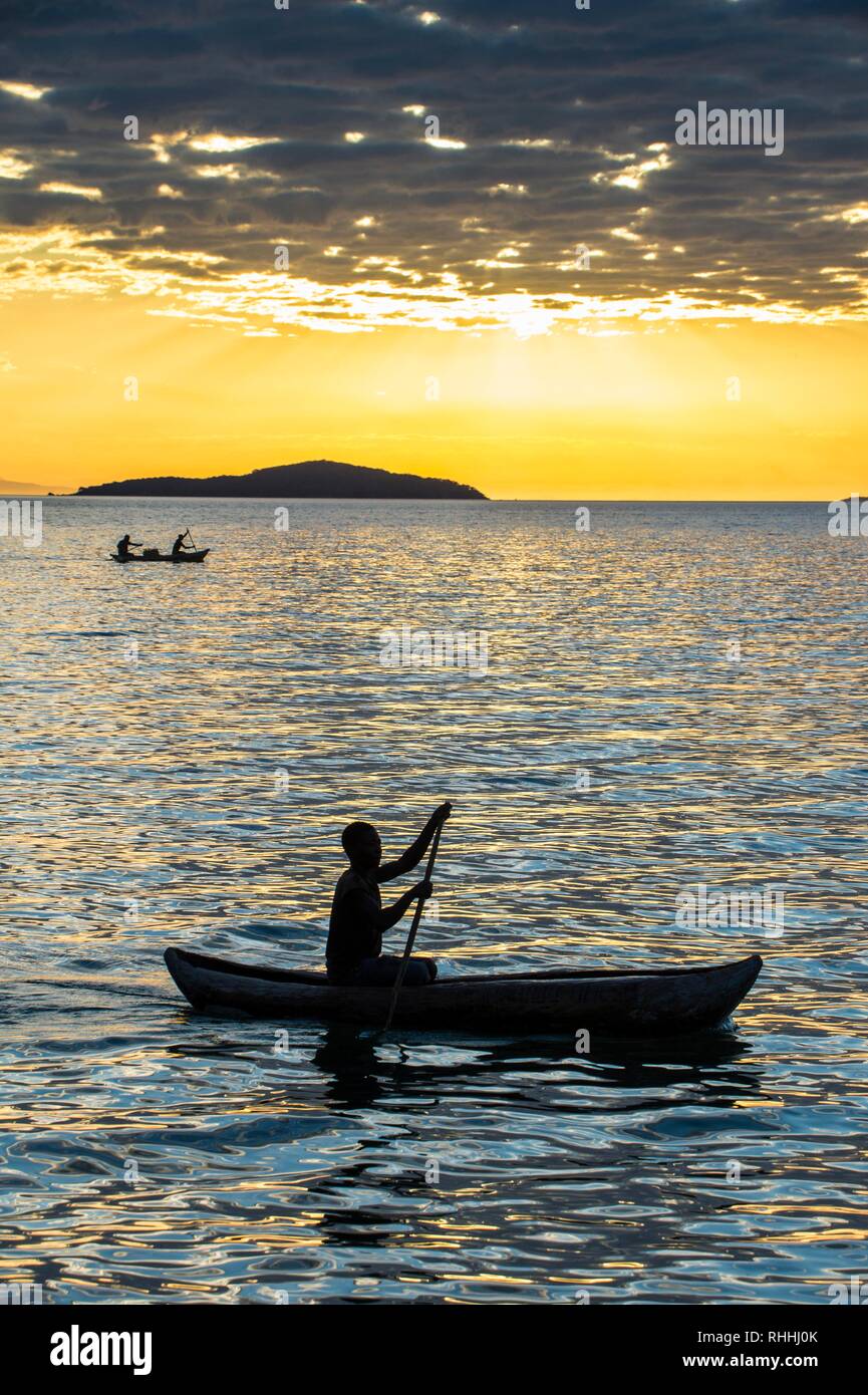 Dans l'homme un peu bateau de pêche au coucher du soleil, le lac Malawi, Cape Maclear, Malawi Banque D'Images