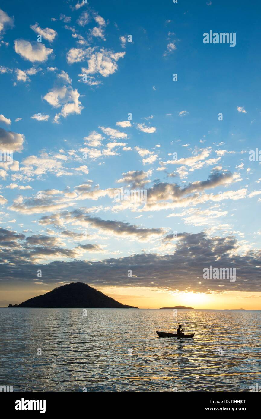 Dans l'homme un peu bateau de pêche au coucher du soleil, le lac Malawi, Cape Maclear, Malawi Banque D'Images