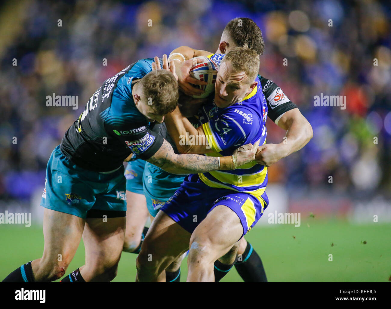 Cheshire, Royaume-Uni. Feb 2019 2ème. Betfred Super League Warrington Wolves v Leeds Rhinos Jason Clark de Warrington Wolves abordé par Liam Sutcliffe (L) et Richie Myler (R) de Leeds Rhinos. Credit : Touchlinepics/Alamy Live News Banque D'Images