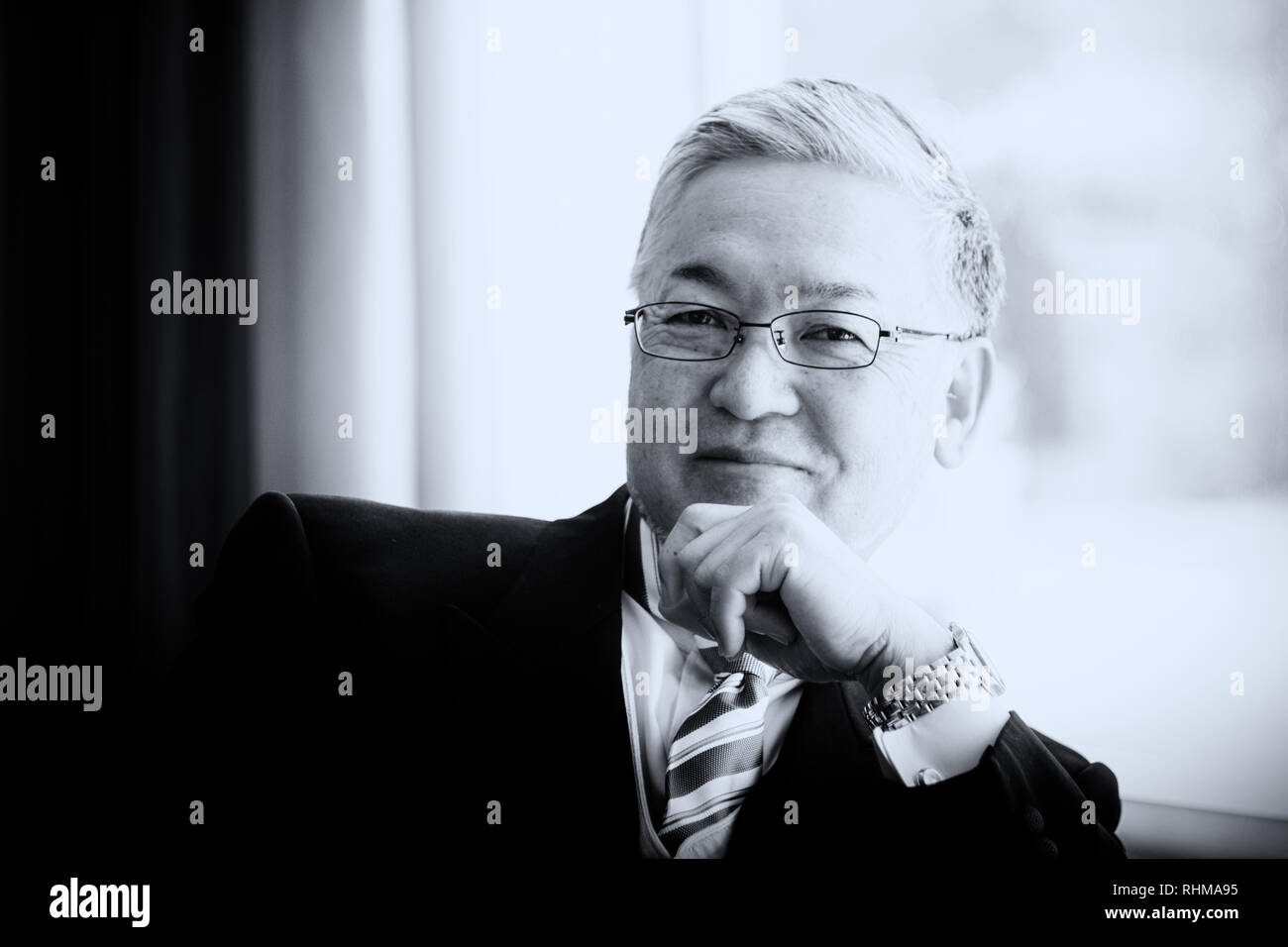 Un beau senior Asian man smiling dans l'appareil photo en vêtements officiels Banque D'Images