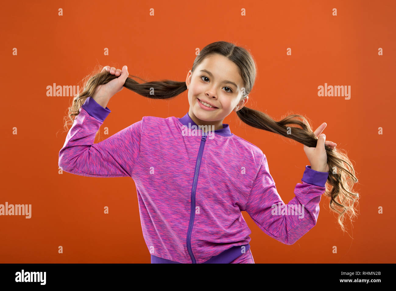 Les petites filles. Coiffure pour les enfants. Aire de jour. Portrait of happy petit enfant. Kid fashion et sportswear. le bonheur de la petite enfance. La famille. Happy little Girl with long hair. Bonjour. Banque D'Images