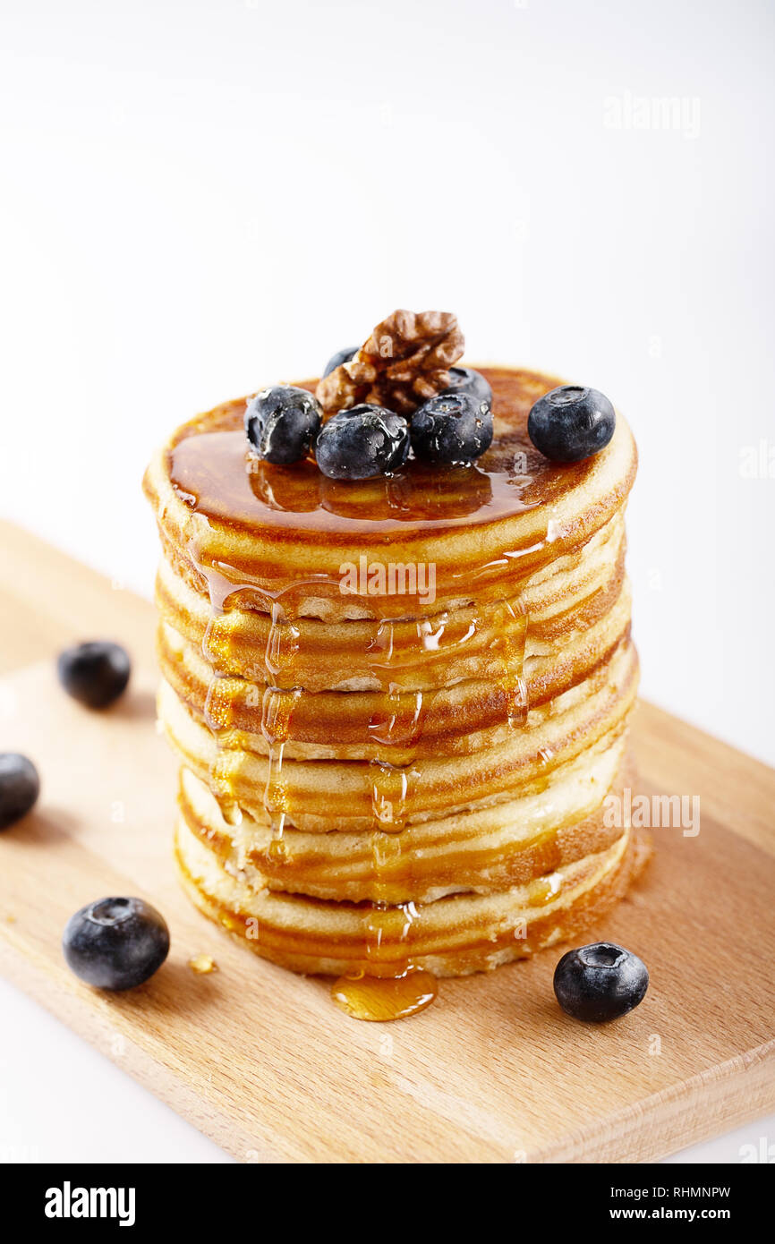 American Sweet des pile de crêpes ou de beignets à blueberry fruits, de noix et de miel, délicieux dessert pour le petit déjeuner, sur fond blanc. Sel Banque D'Images