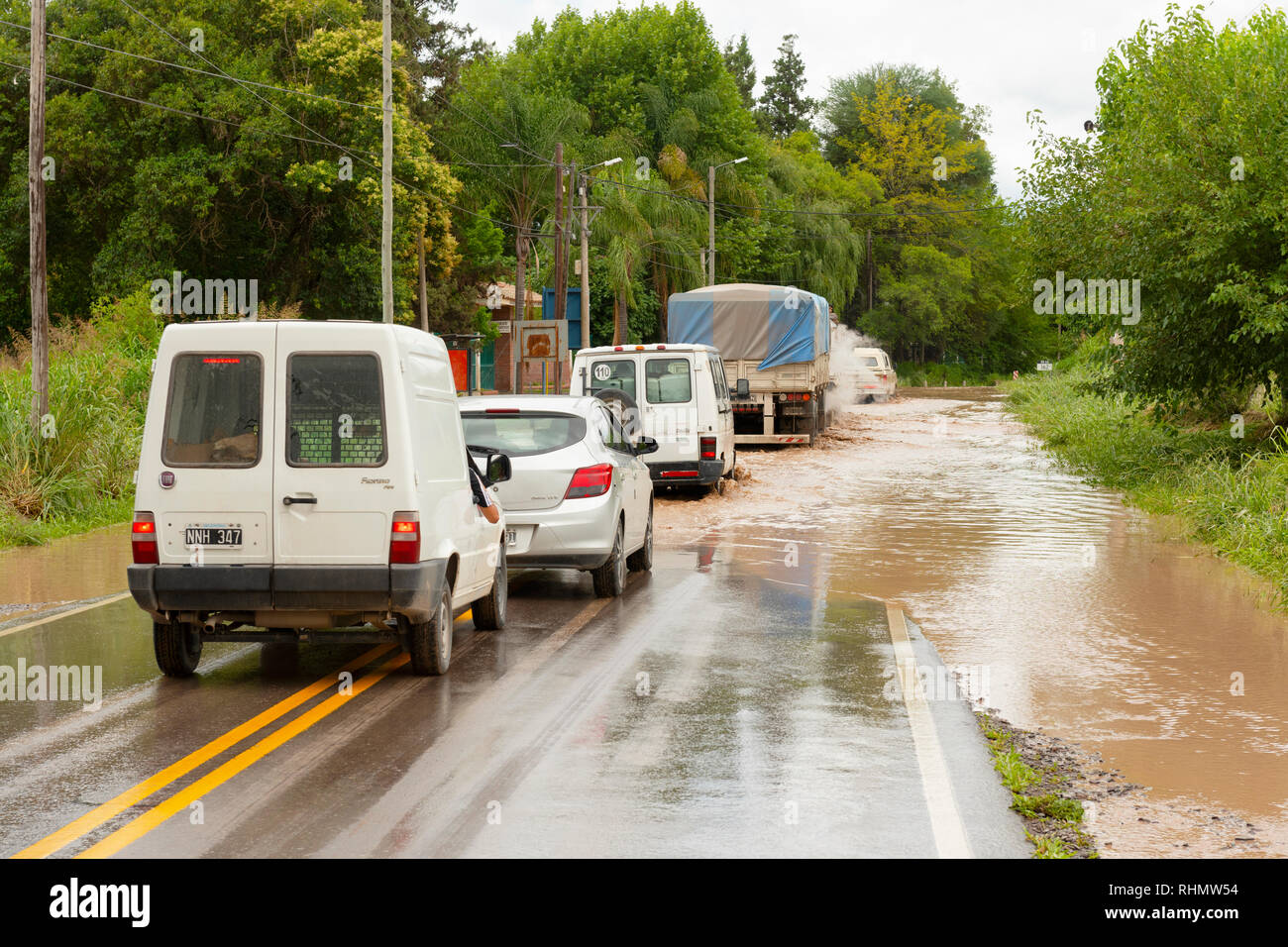 Une ligne de trafic entrant dans une zone inondée de la route dans l'espoir qu'il est praticable. Image prise sur la Route 68, près de El Carril, Province de Salta, Argentine. Banque D'Images