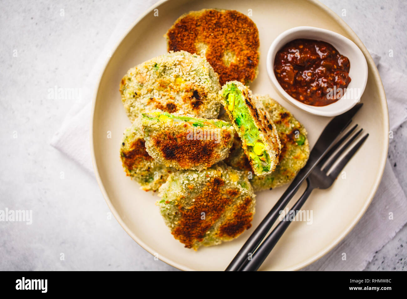 Veggie vert les escalopes dans un plat blanc avec sauce tomate sur fond blanc. Vegn saine food concept. Banque D'Images