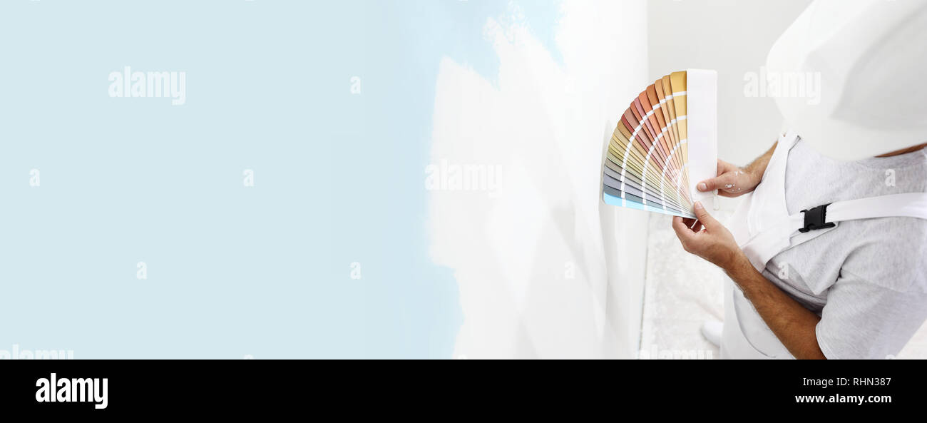 Homme peintre avec échantillons de couleur dans votre main, d'un choix de couleurs concept, sur grand mur vide pour copier l'espace et le fond de la bannière web Banque D'Images