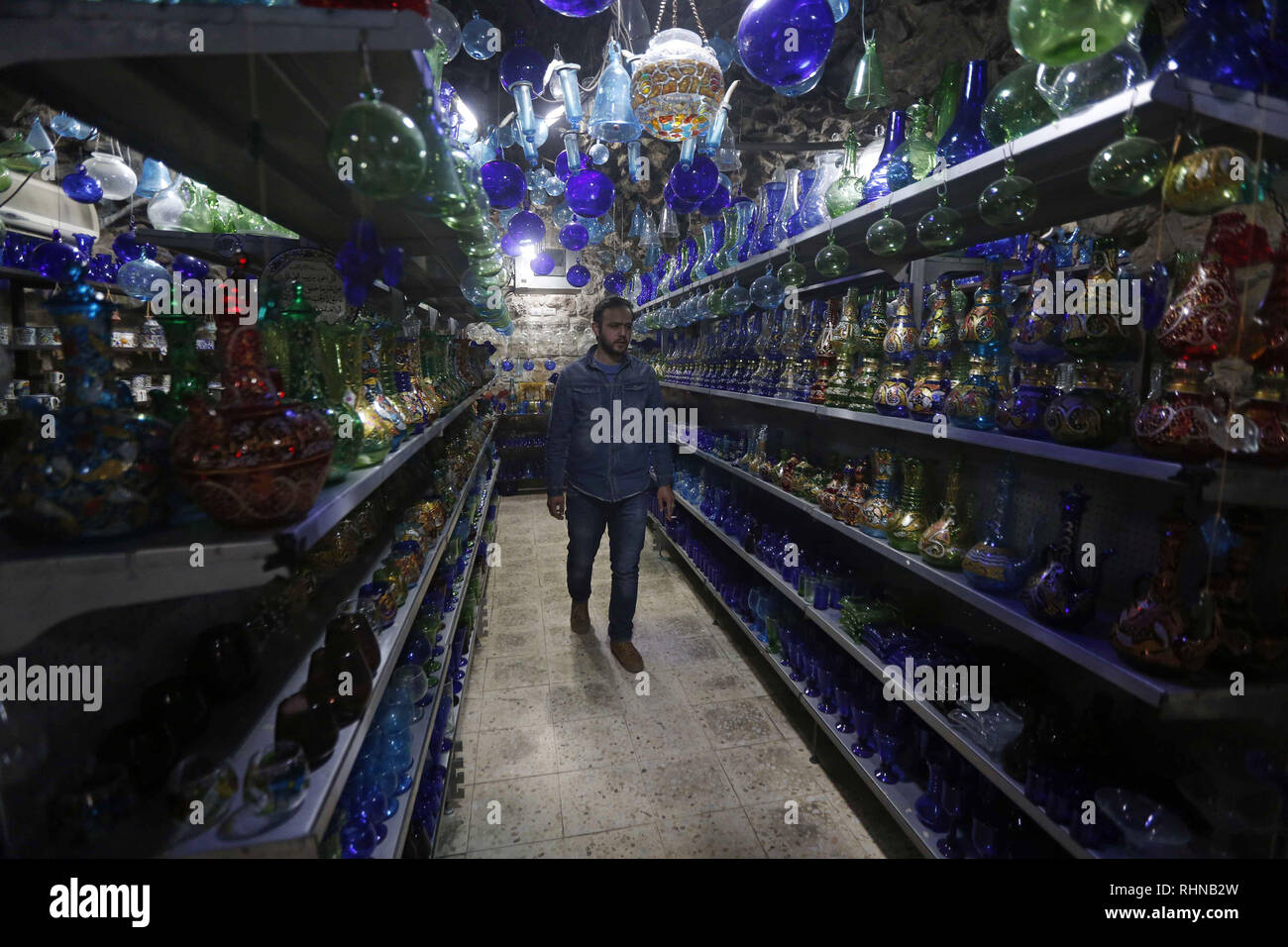 Hébron, en Cisjordanie, en territoire palestinien. 3, 2019. Un Palestinien inspecte un morceau de verre dans un atelier de verre soufflé près de la mosquée Ibrahimi, dans la ville de Cisjordanie d'Hébron. Un verrier ou le concepteur est responsable de la conception, de la production, la décoration et la finition des morceaux de verre, y compris verre architectural, pièces d'exposition, articles cadeaux, miroirs, vitraux, verre, des fenêtres et de la table Crédit : Hashlamoun Wisam APA/Images/ZUMA/Alamy Fil Live News Banque D'Images