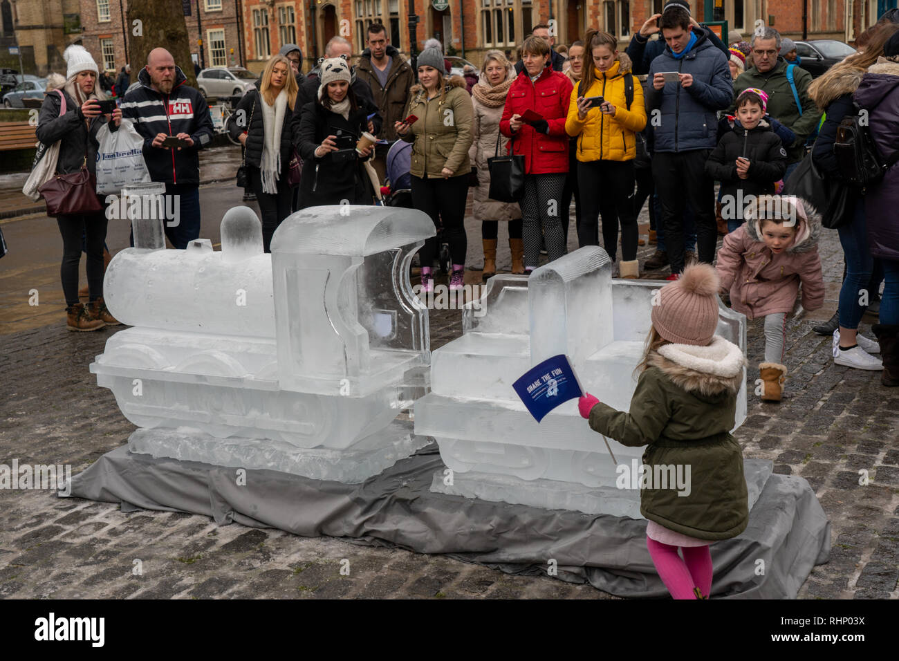Une foule de personnes se sont rassemblées autour d'une sculpture représentant un train de glace le long de la piste de glace Myths et Legends York, dans le North Yorkshire, en Angleterre, au Royaume-Uni. Banque D'Images