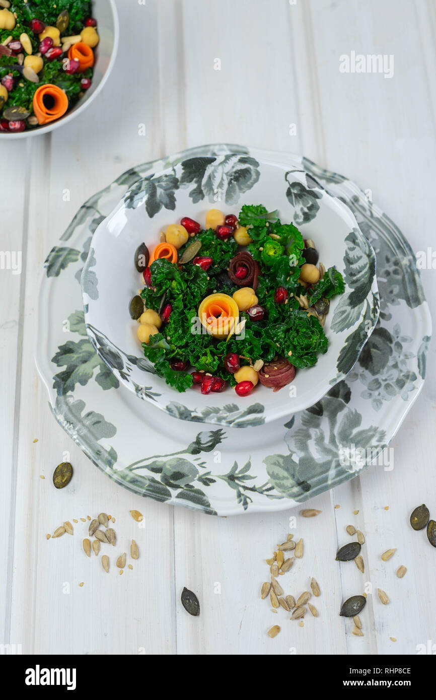 Bol avec kalettes (un croisement entre le chou de Bruxelles et le chou vert), les pois chiches, les carottes colorées, graines de grenade et de diverses graines Banque D'Images