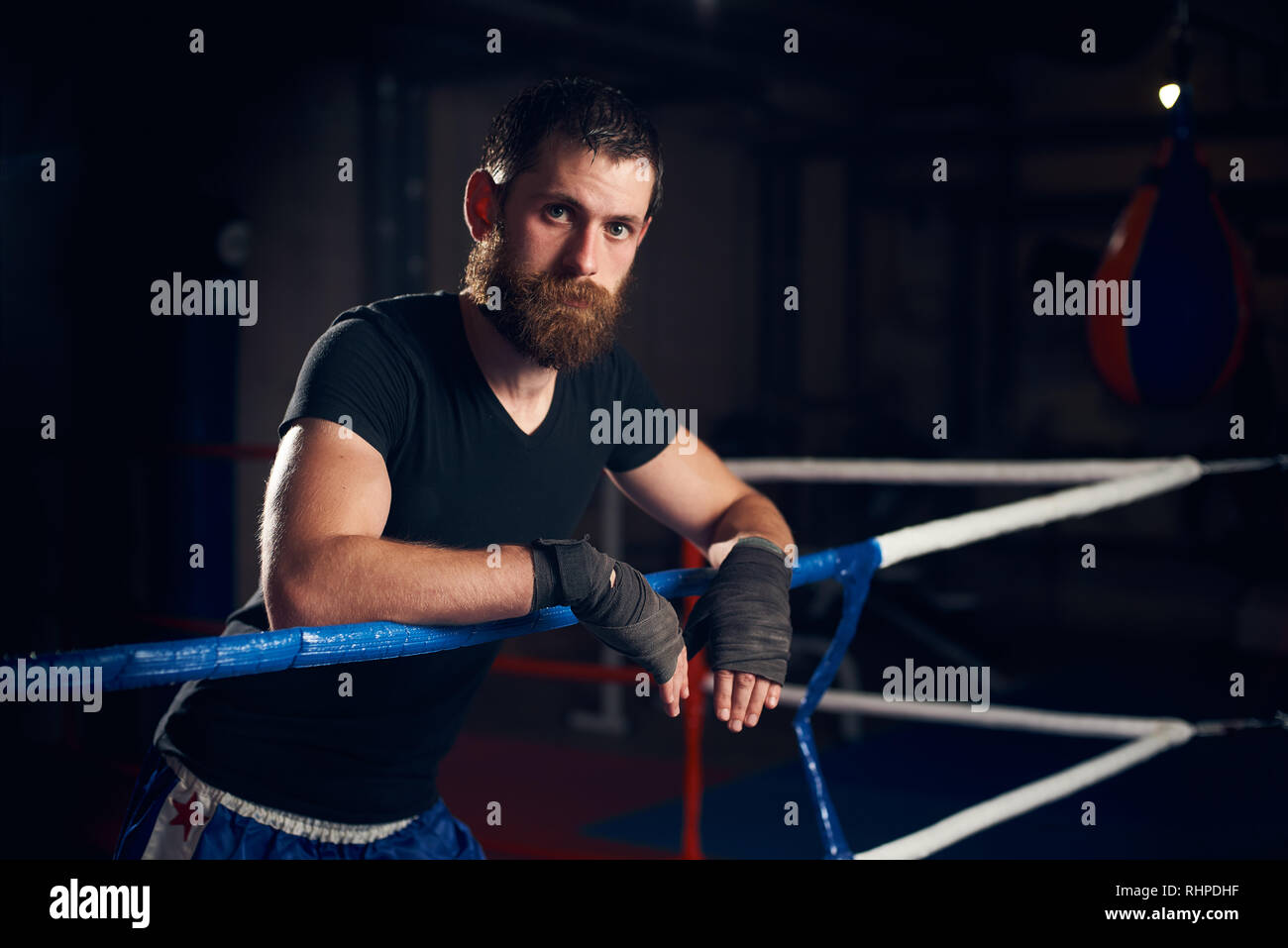 Portrait of young male boxer debout dans l'anneau dans le club de boxe d'entraînement dur après Banque D'Images