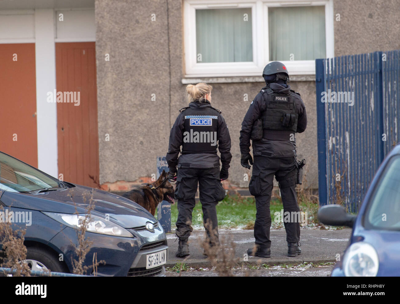 La police armée et de chien à l'extérieur des unités d''une télévision à Stenhouse Street West, Édimbourg Banque D'Images