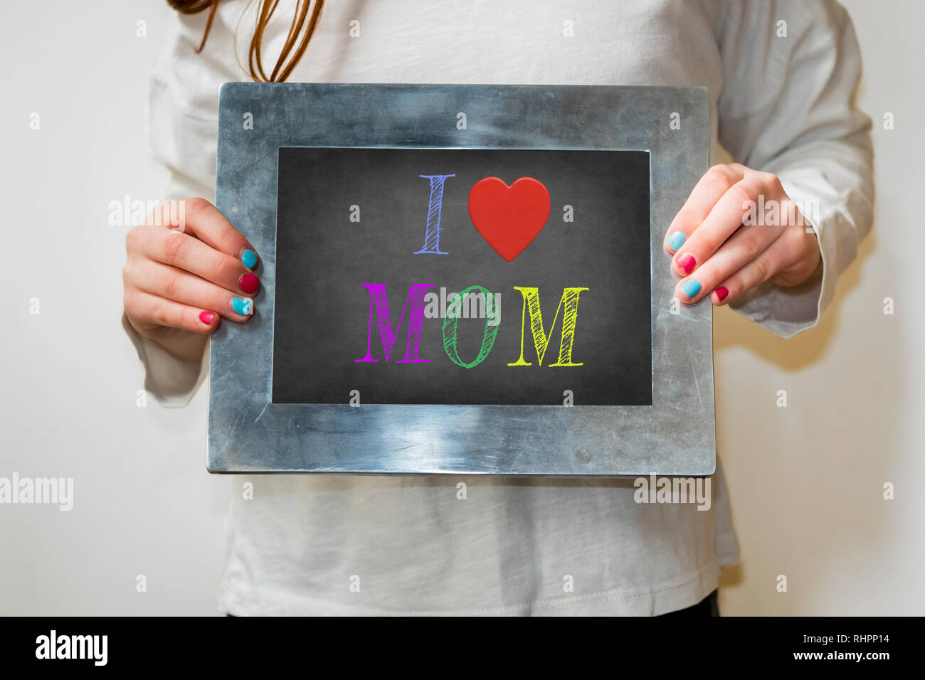 Girl holding up un tableau avec les mots J'aime maman écrit à la craie Banque D'Images