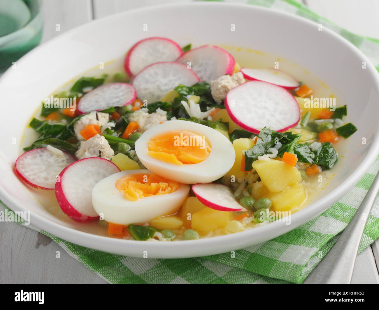 Soupe de printemps aux épinards, pomme de terre, carotte, chou-fleur, radis, petits pois et oeuf dur Banque D'Images