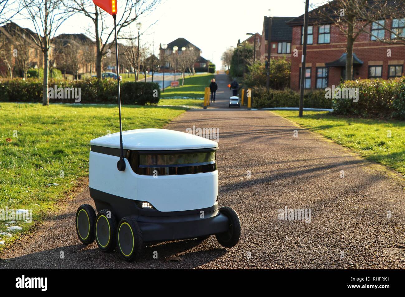 Les piétons passer au sujet de leur vie quotidienne en tant que technologies Starship robots autonomes faire les livraisons d'épicerie de routine autour de Milton Keynes. Banque D'Images