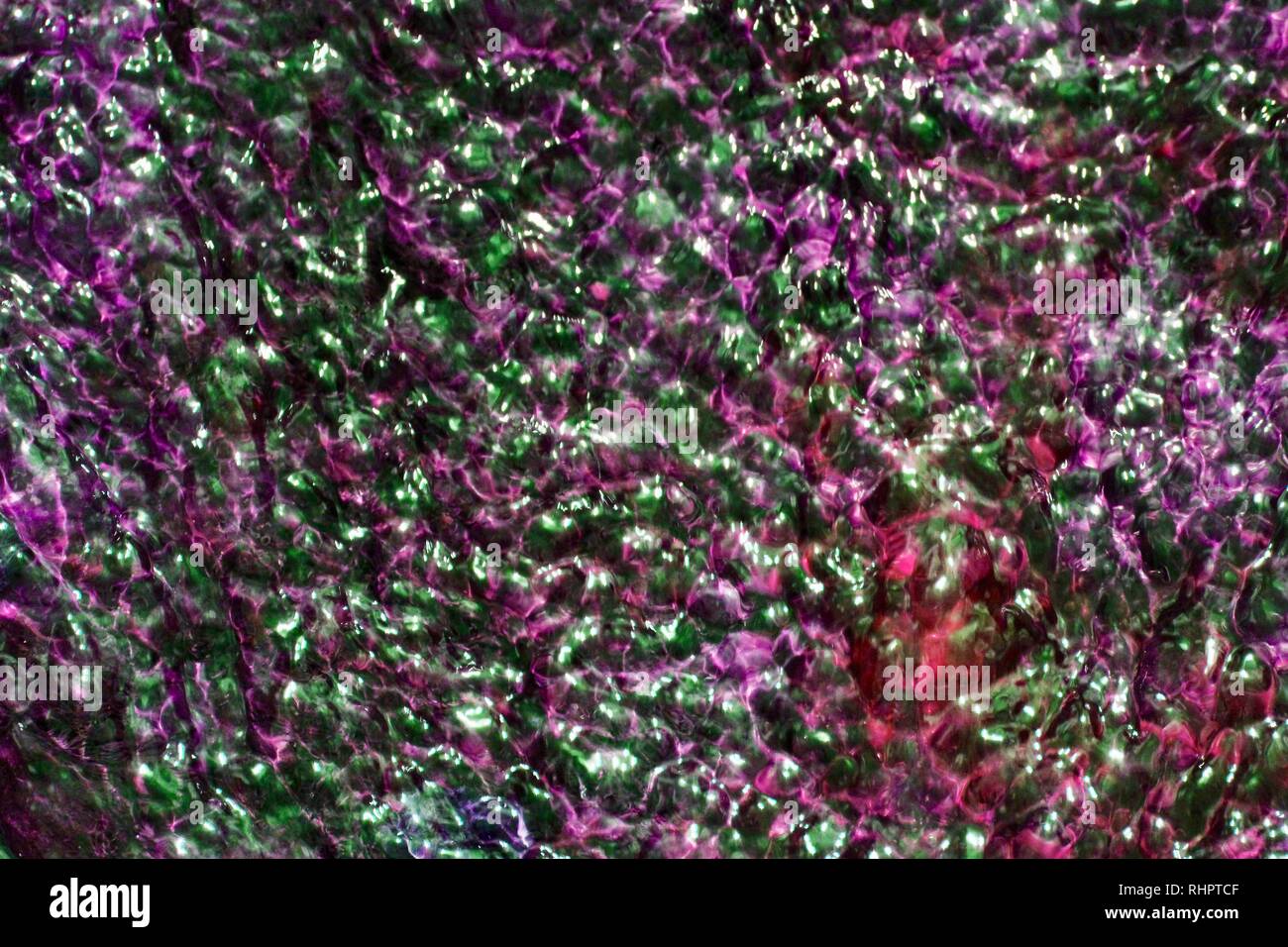 Les ondulations de l'eau violet teinté et texture de fond rouge Banque D'Images