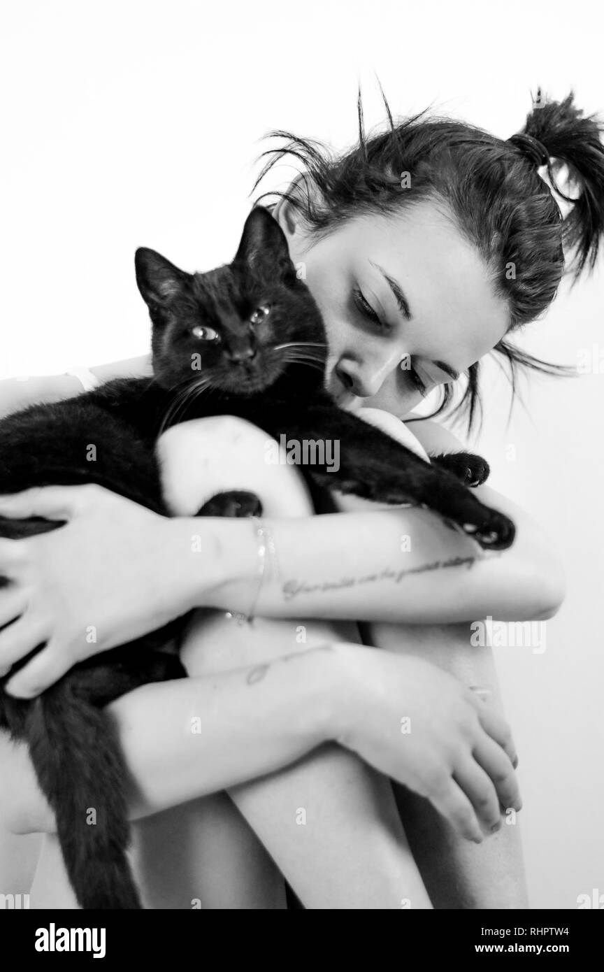 Jeune fille jouant avec son chat noir Banque D'Images