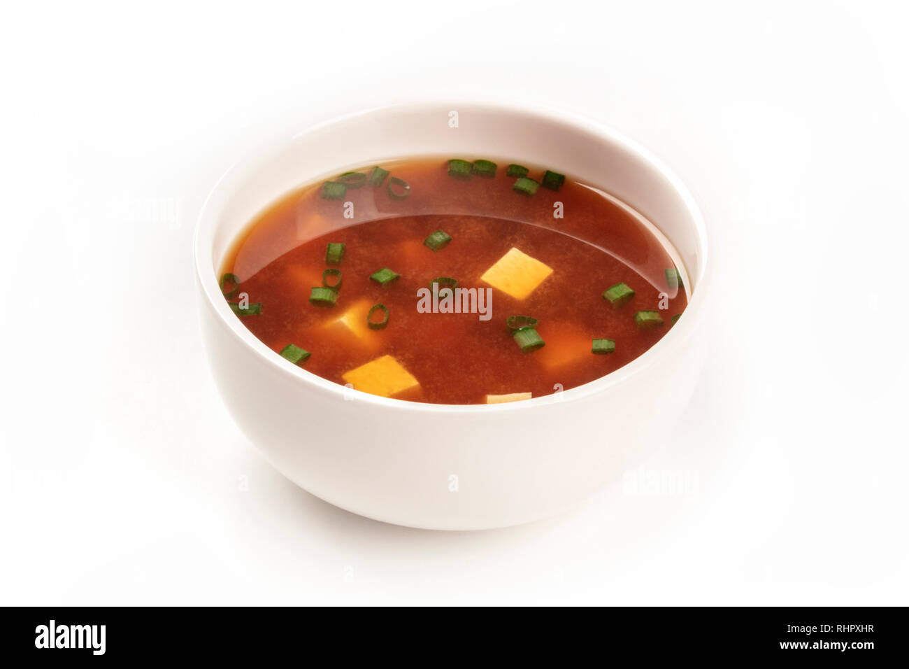 Une photo d'un bol de soupe miso au tofu et oignons verts sur fond blanc avec copie espace Banque D'Images