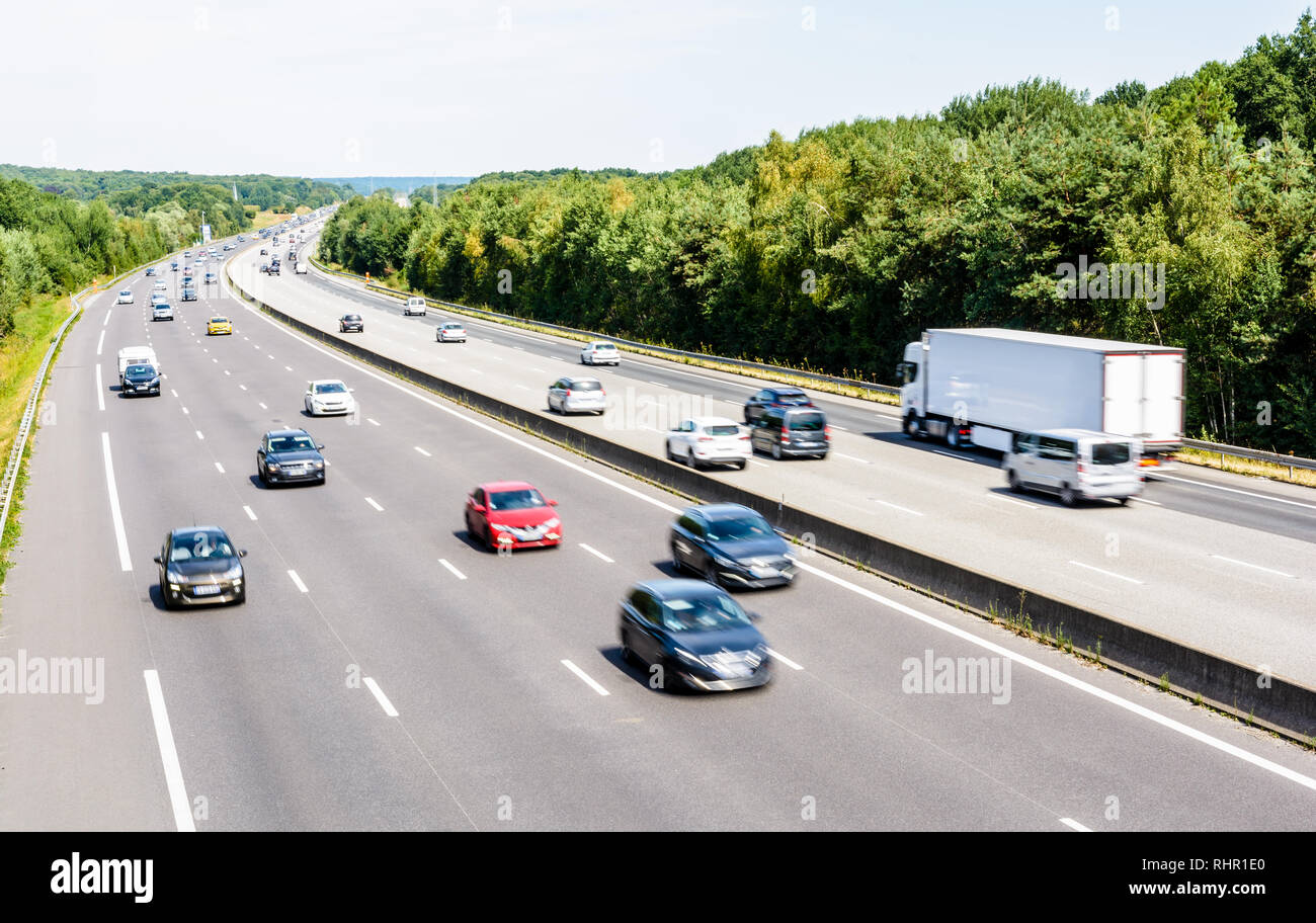 Mais le trafic fluide lourd sur l'autoroute A10 en France en direction de Paris sur une chaude journée d'été avec des voitures, fourgons, remorques et semi-remorque roulant. Banque D'Images