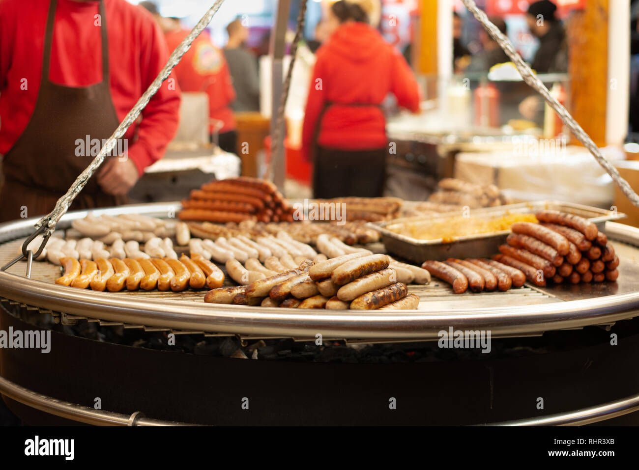 Les saucisses sur le gril au soir du marché de Noël Banque D'Images