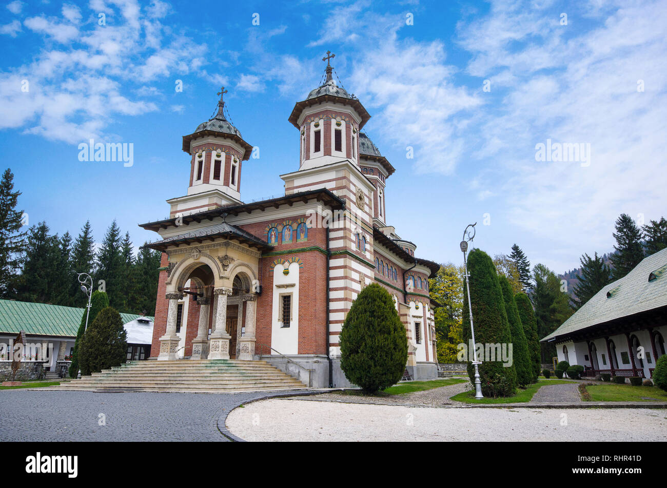 Vue avant le jour de l'église orthodoxe à Sinaia monastery à Prahova, Transylvanie, Roumanie. Les arbres verts et lumineux blue cloudy sky Banque D'Images