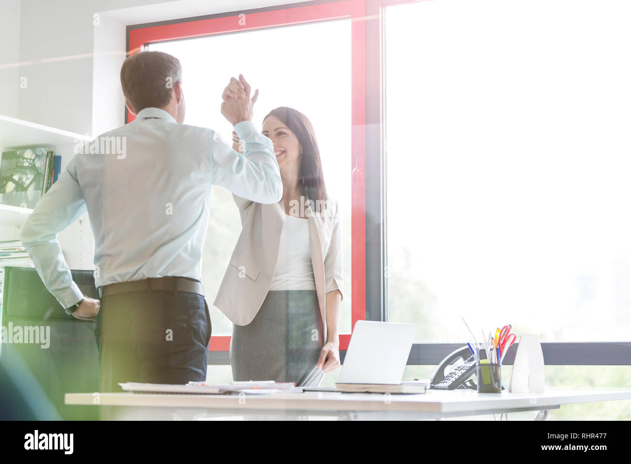 Heureux les gens d'affaires de haut donnant cinq at desk in office Banque D'Images