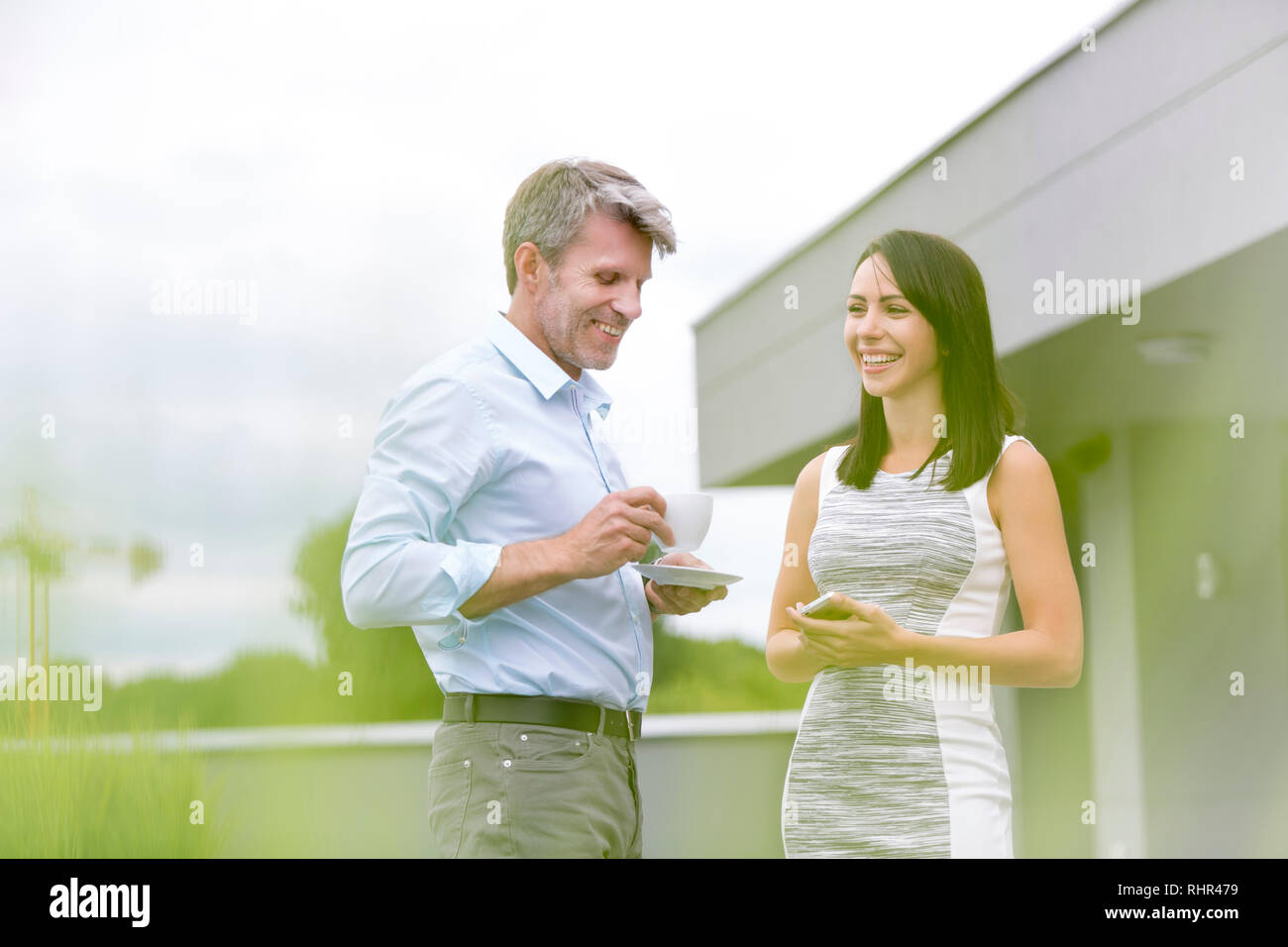 Smiling business people talking au cours de pause café en terrasse bureau Banque D'Images Smiling business people talking au cours de pause café en terrasse bureau Banque D'Images