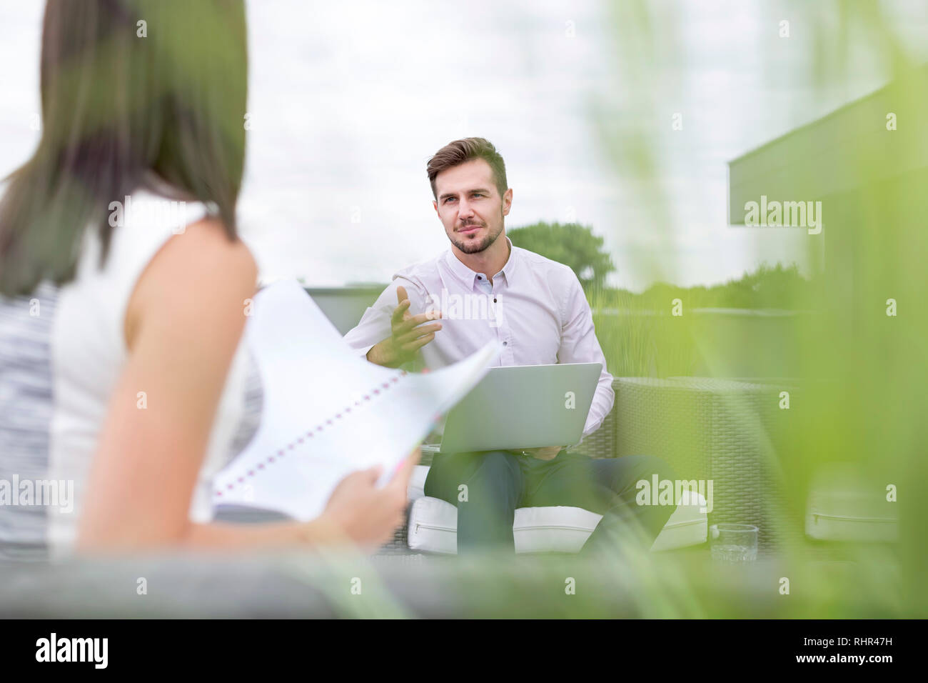 Des collègues de discuter plus de documents en terrasse bureau Banque D'Images