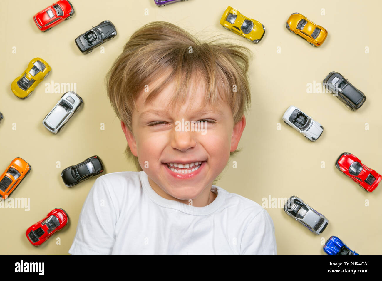 Jeune garçon avec des petites voitures jouets colorés Banque D'Images