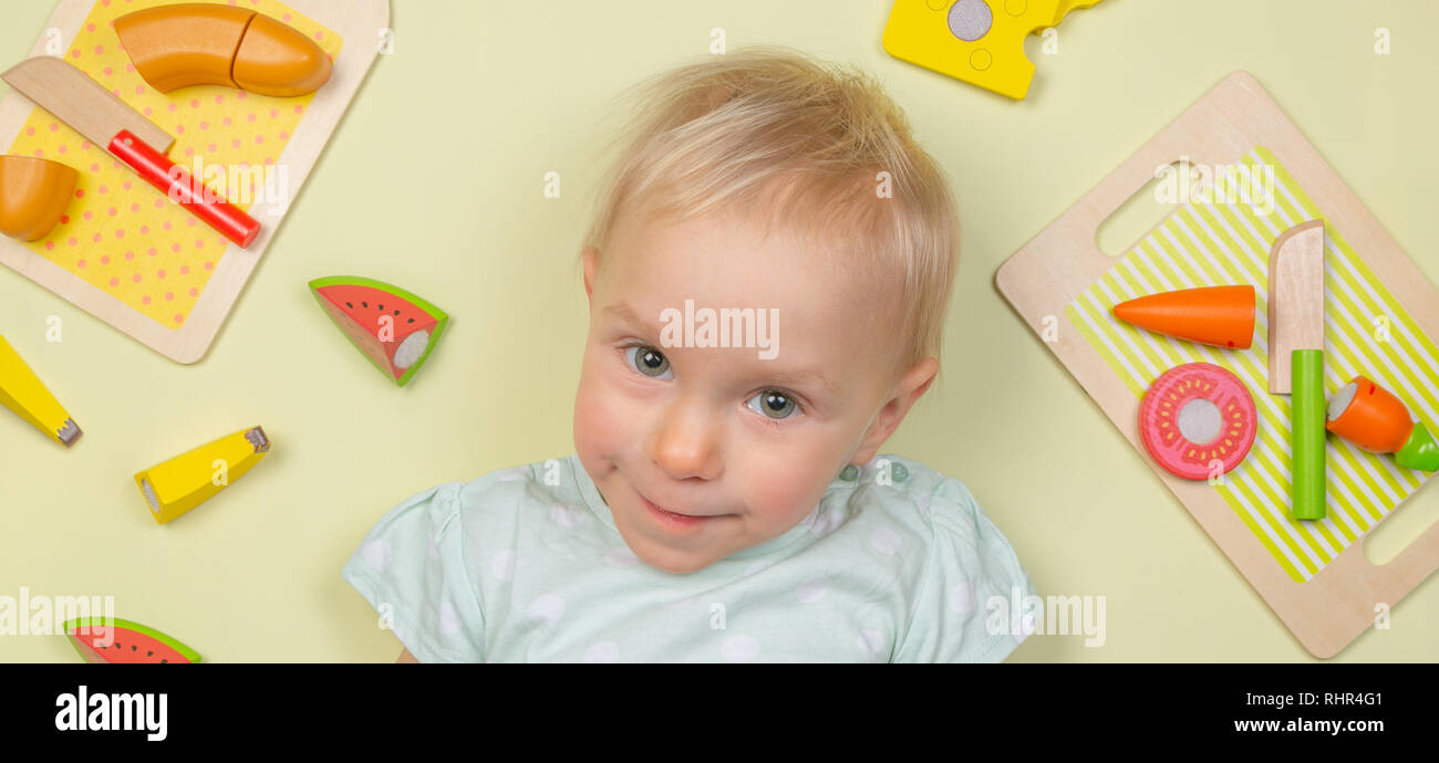 Bébé souriant avec des jouets en bois pour bébé produits et ingrédients Banque D'Images