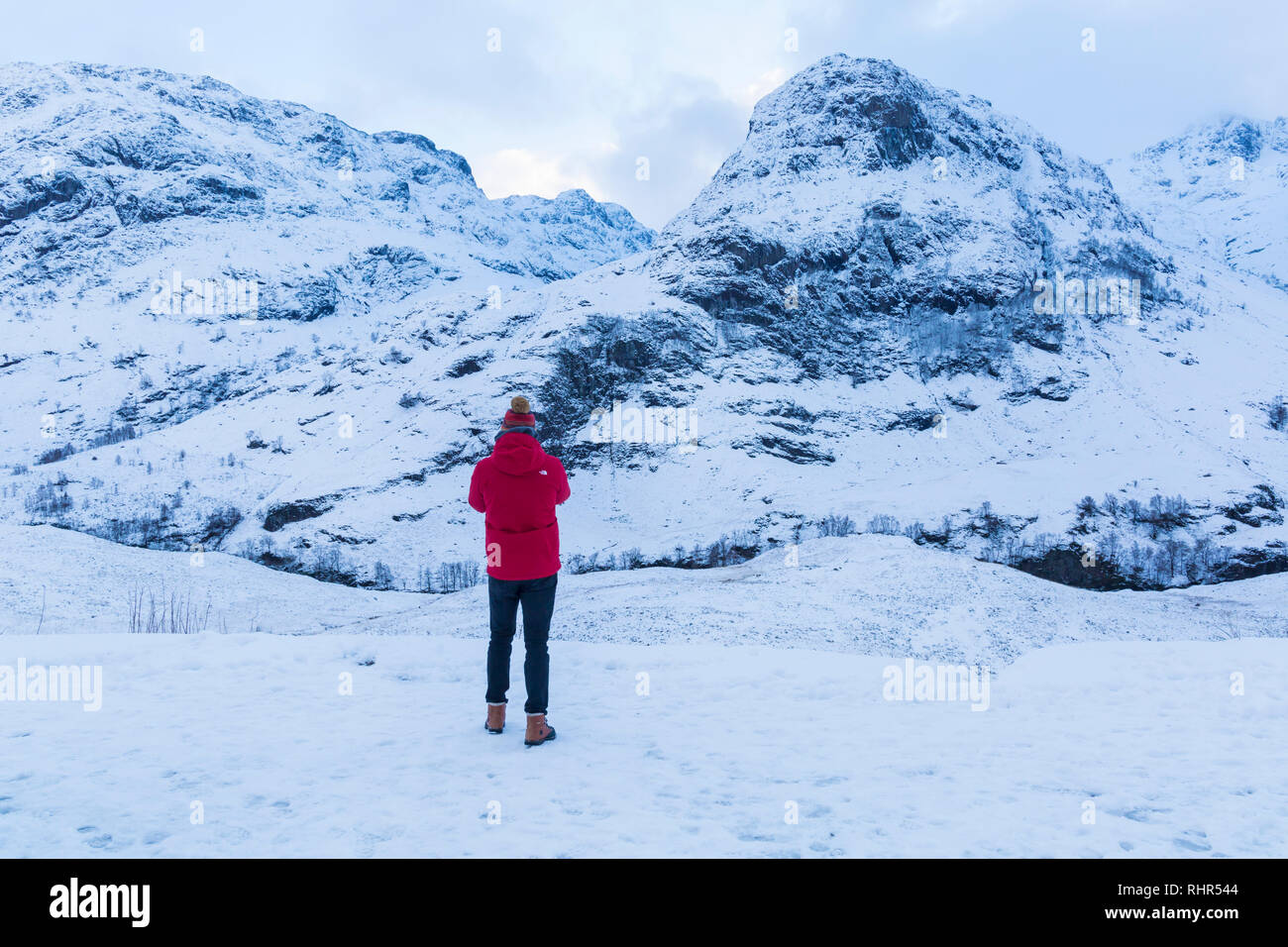 Les touristes à la recherche à la montagnes couvertes de neige des trois Sœurs du point de vue de A82 à Glencoe, Highlands, Scotland en hiver Banque D'Images