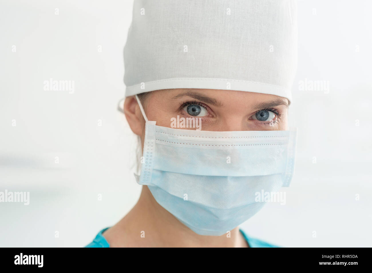 Closeup portrait of female doctor wearing surgical mask et cap à la clinique Banque D'Images