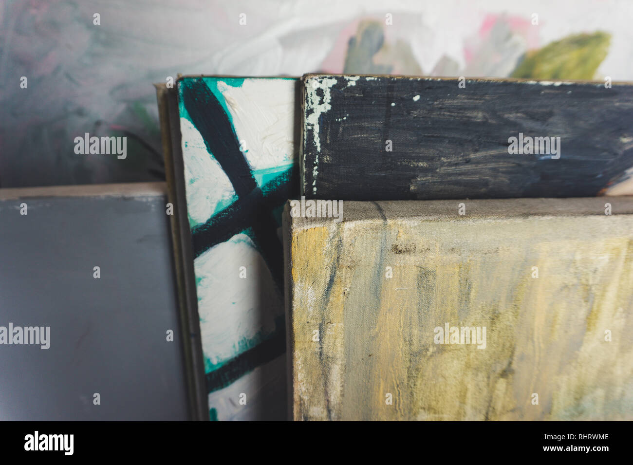 Fine art peintures sur toile empilés dans un studio d'art de l'artiste -- vu close up avec éclairage moody Banque D'Images