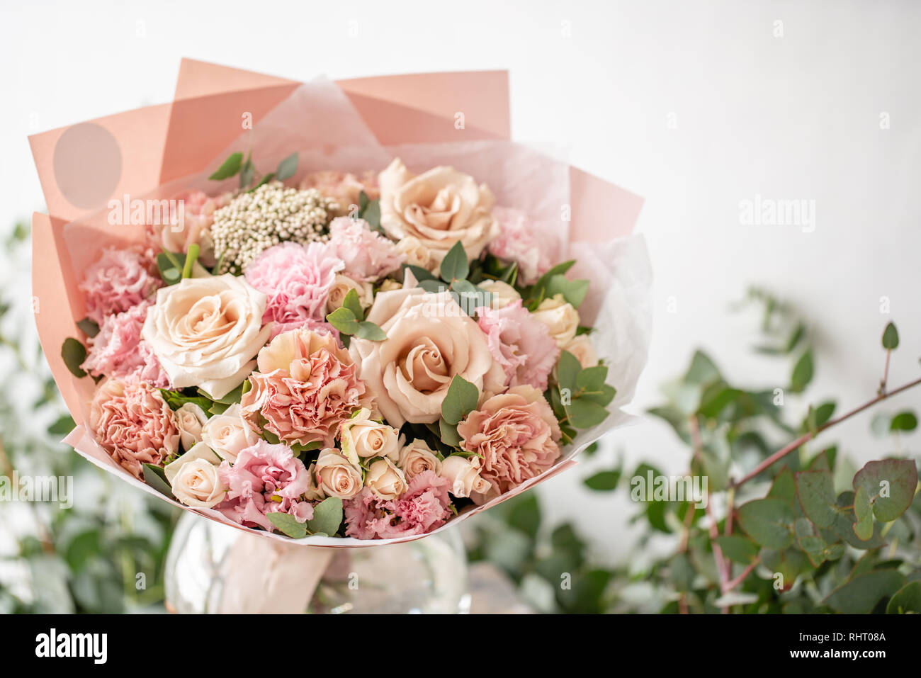 Belle de bouquet de fleurs dans un vase sur la table en bois. Le travail de  la fleuriste à un magasin de fleur. Couleurs pastel délicates Photo Stock -  Alamy