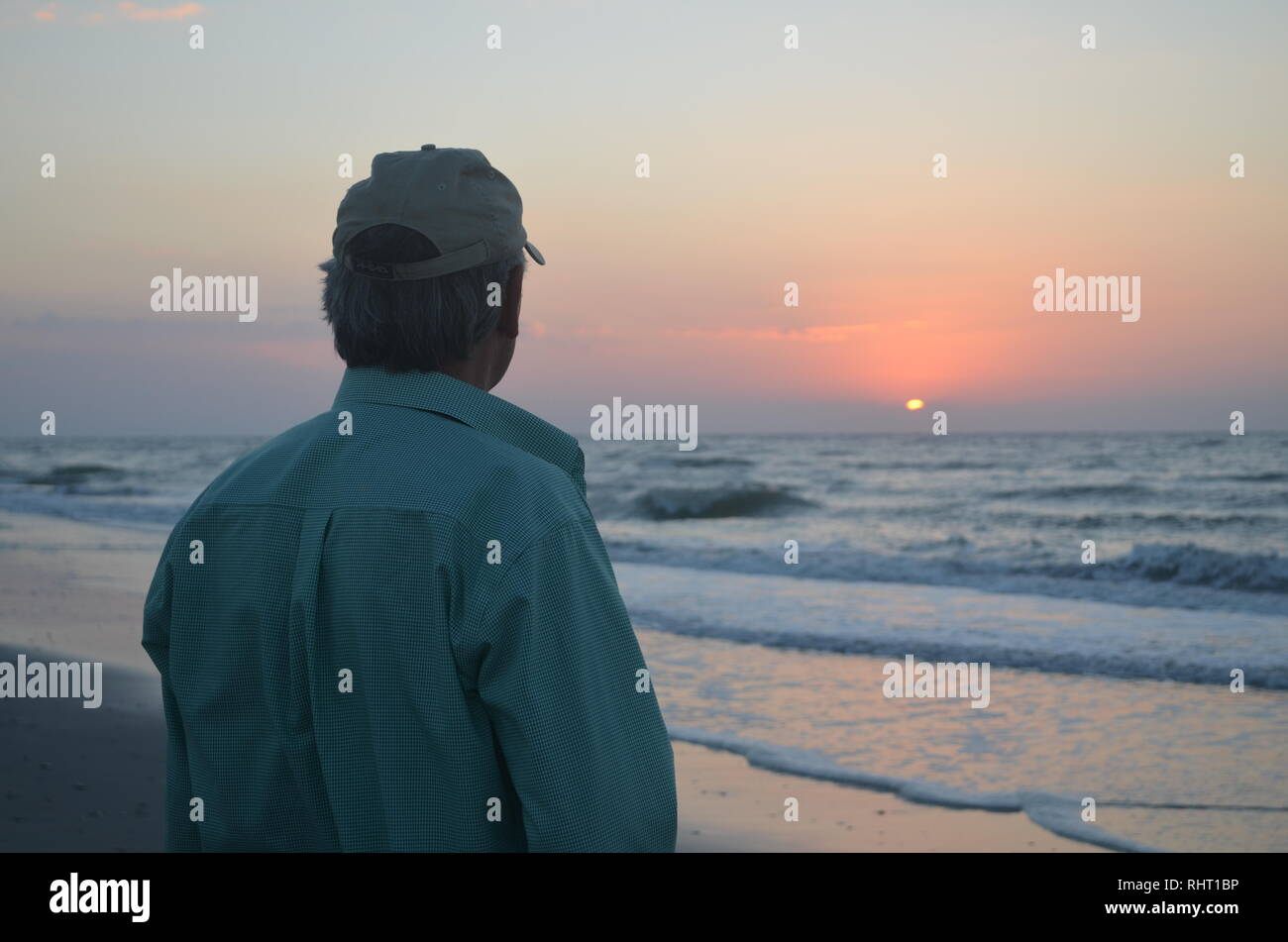 L'homme regardant le lever du soleil sur U,S. Côte Est Banque D'Images