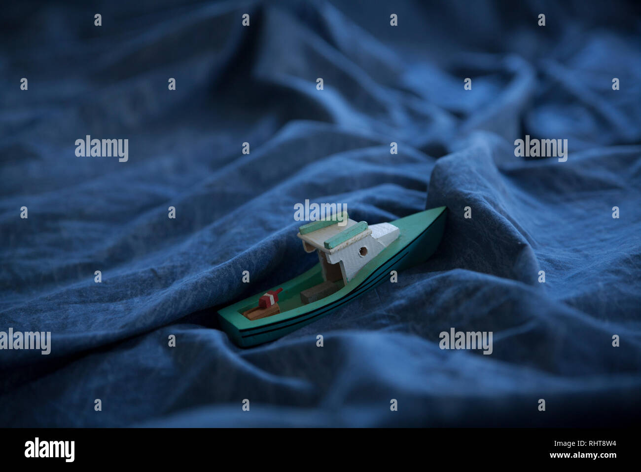 Un jouet bateau en haute mer dans un couvre-lit. Banque D'Images
