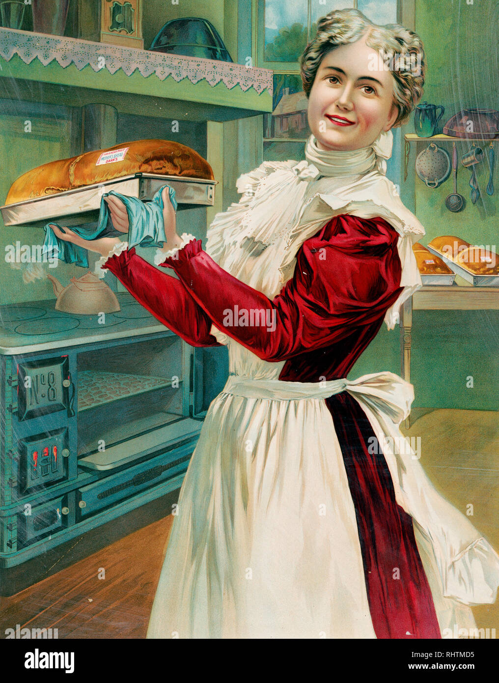 Imprimer montre une femme bien habillé portant un tablier, la cuisson du pain dans un home-style cuisine ; elle est debout, de trois-quarts, de face, tenant un pan du pain frais cuit dans une publicité pour la J.A. Dahn & Son Baking Company. Banque D'Images