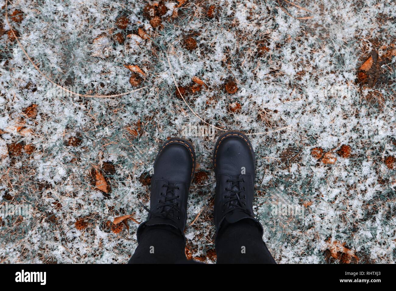 Le Dr Martens sur neige avec les feuilles tombées Photo Stock - Alamy